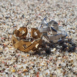 Silver & 18k gold Crisscross Rings by Divine Me Essentials, on a sandy beach in New Zealand. Size-inclusive rings.